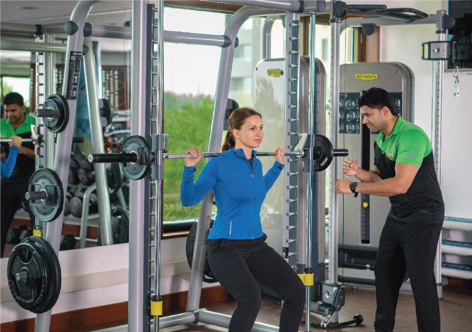 Jumeirah Messilah Beach Kuwait Kuwait City Exterior photo A personal trainer assisting a woman with a weight training exercise